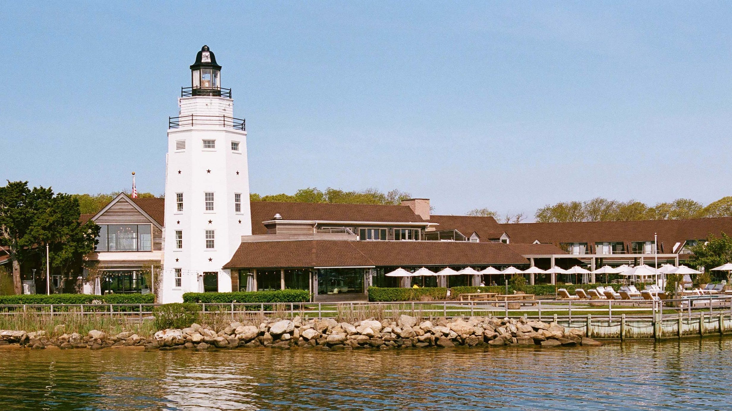 A photograph of the resort at the dockyard with a lighthouse to the left.