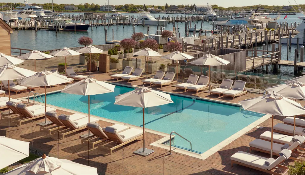 An aerial photo reveals lounge chairs surrounding the poolside at the dockyard's edge.